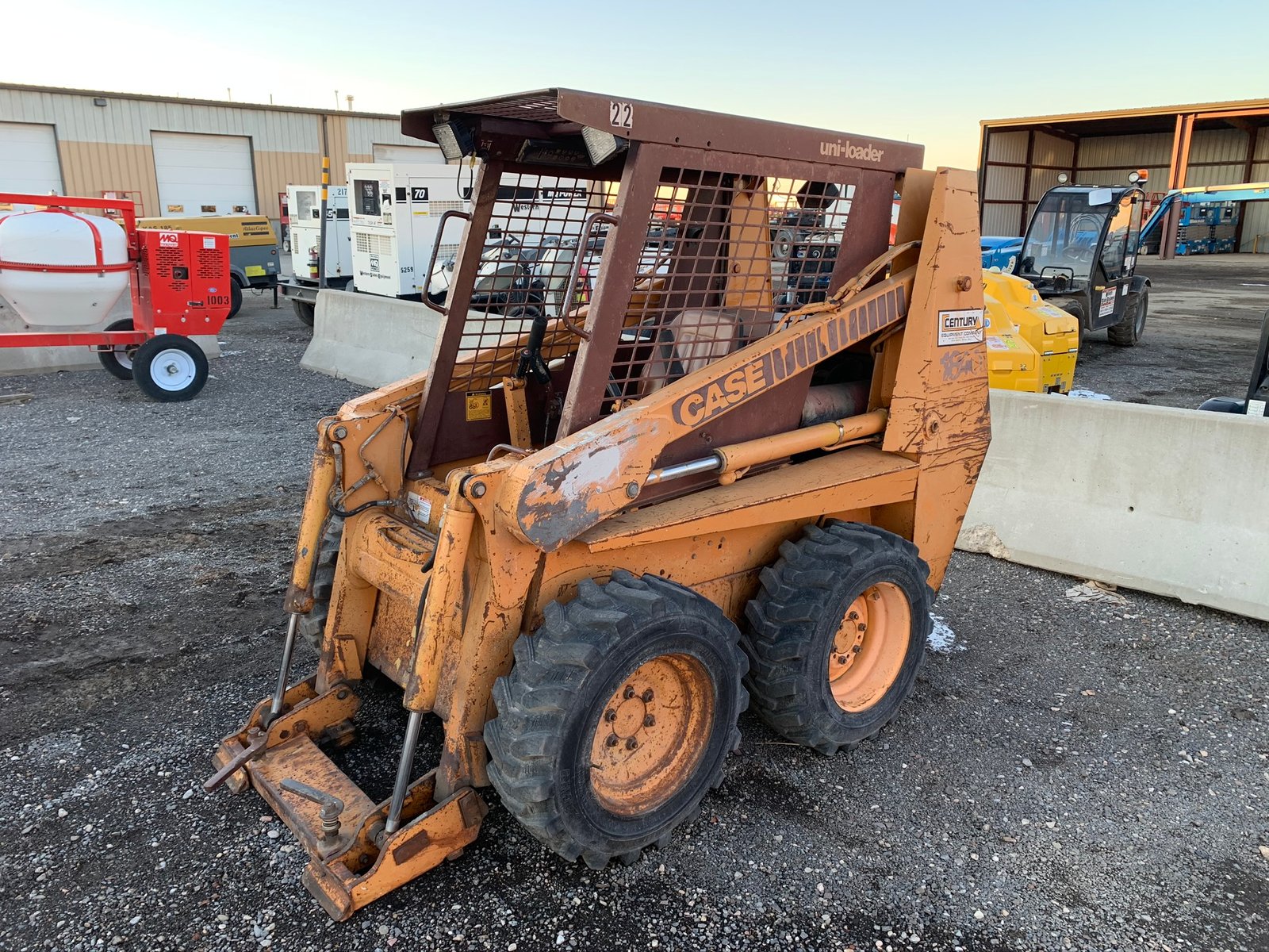 Old Bobcat skid steer with bucket parked outdoors